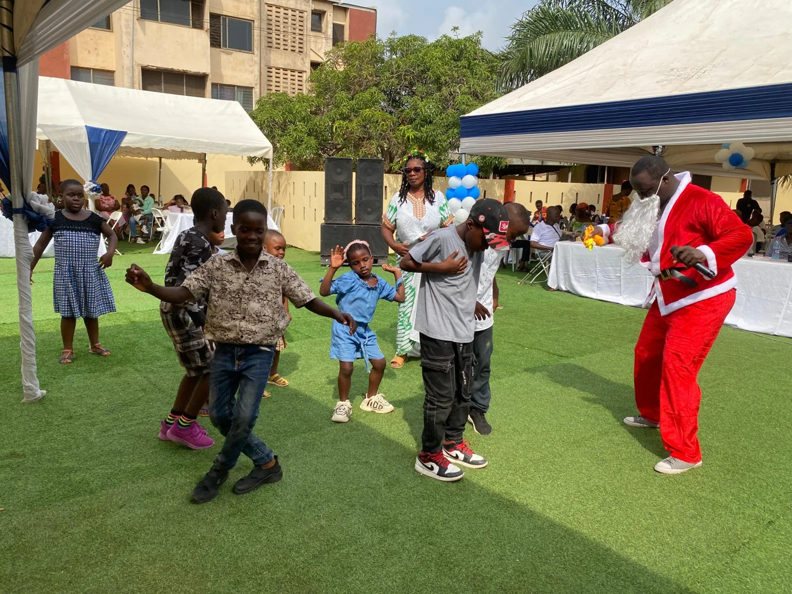 Children dancing on the lawn during an outdoor celebration.