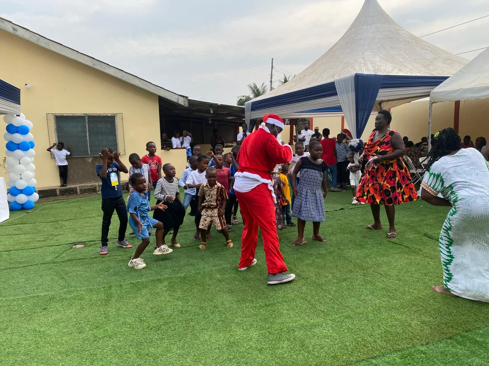 Children and an entertainer taking part in outdoor activities.